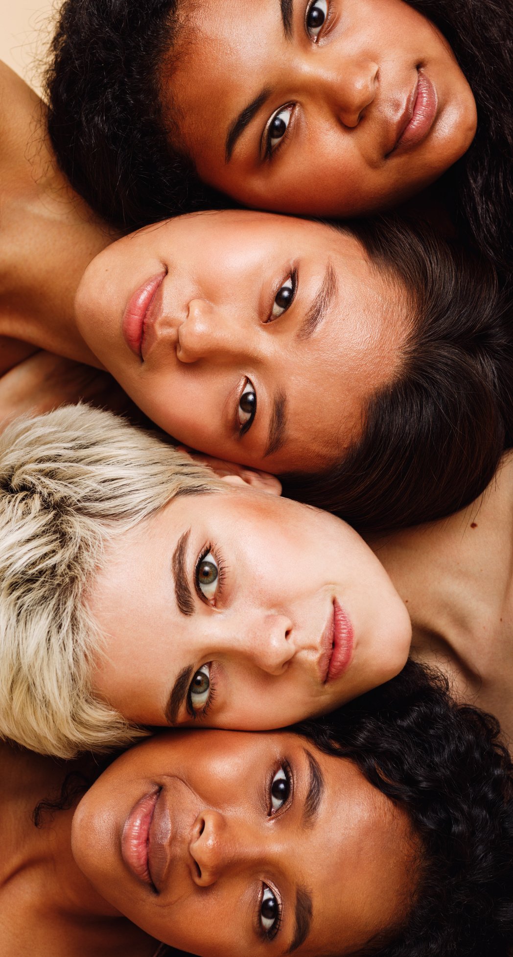 Beautiful young women lying on top of each other, looking at camera